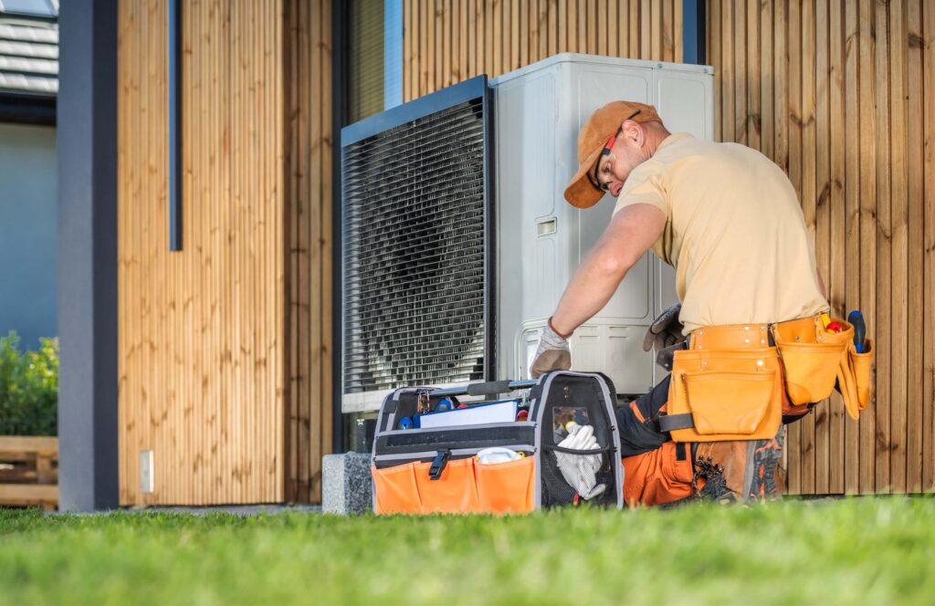 HVAC worker on a heat pump HVAC worker on a heat pump outside a home