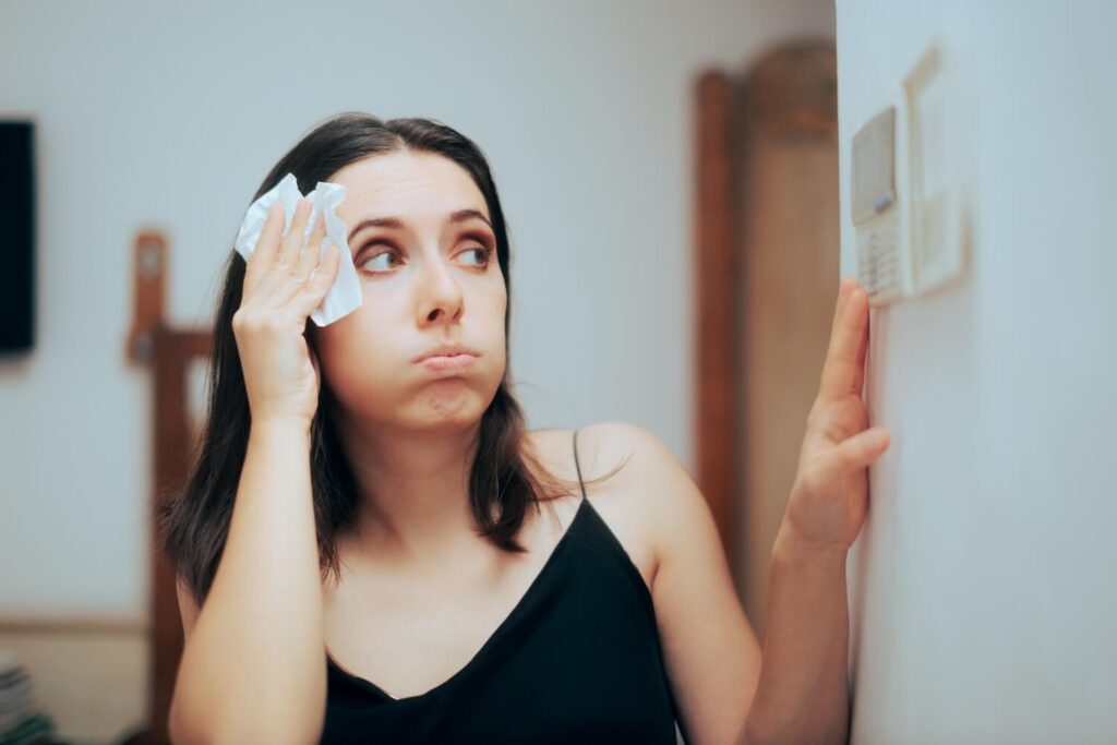 Person adjusting temperature from AC settings